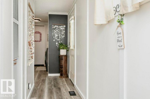 Corridor with a textured ceiling, wood finished floors, and a heating unit - 216 53222 Rge Rd 272, Rural Parkland County, AB - Indoor Photo Showing Other Room