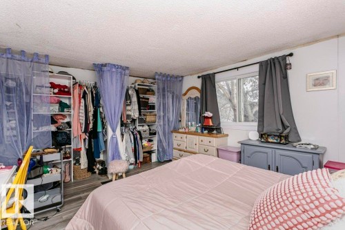 Bedroom featuring a textured ceiling and dark wood finished floors - 216 53222 Rge Rd 272, Rural Parkland County, AB - Indoor Photo Showing Bedroom