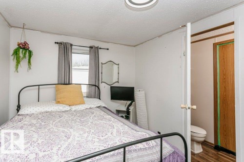 Bedroom featuring a textured ceiling and wood finished floors - 216 53222 Rge Rd 272, Rural Parkland County, AB - Indoor Photo Showing Bedroom