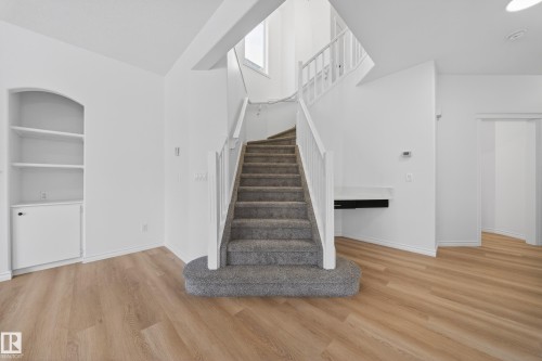 Stairs featuring built in features, wood finished floors, and a high ceiling - 1741 63A Street, Edmonton, AB - Indoor Photo Showing Other Room