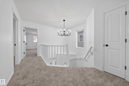 Corridor featuring an upstairs landing, carpet, and a chandelier - 1741 63A Street, Edmonton, AB - Indoor Photo Showing Other Room