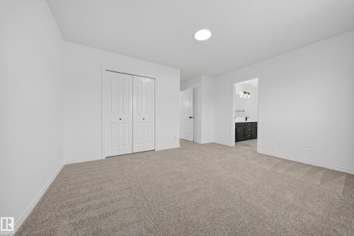 Unfurnished bedroom featuring light colored carpet, a closet, and connected bathroom - 1741 63A Street, Edmonton, AB - Indoor Photo Showing Other Room