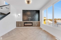 Unfurnished room with healthy amount of natural light and a glass covered fireplace - 