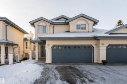 View of front of property featuring concrete driveway and stucco siding - 