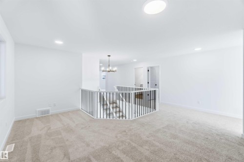 Empty room with light colored carpet, recessed lighting, and a chandelier - 2211 4 Avenue, Edmonton, AB - Indoor Photo Showing Other Room