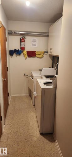 Shared laundry featuring a textured ceiling and separate washer and dryer - 9540 - 100 Avenue, Westlock, AB - Indoor