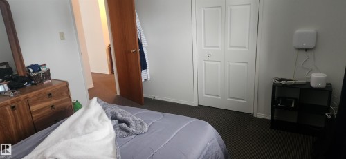 Bedroom featuring a closet and dark colored carpet - 9540 - 100 Avenue, Westlock, AB - Indoor Photo Showing Bedroom