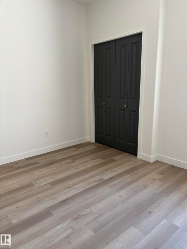 Room featuring light-toned wood-finish flooring, white baseboards, and white walls - 6 4 Avenue, Hay Lakes, AB 