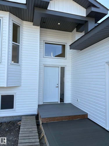 Contemporary exterior featuring white horizontal siding and dark gray trim - 6 4 Avenue, Hay Lakes, AB 