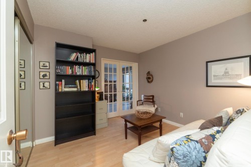 Bedroom with french doors, light wood-style flooring, and a textured ceiling - 203 10171 119 Street Nw, Edmonton, AB - Indoor