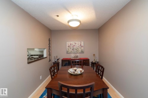 Dining area featuring a textured ceiling and light wood-style flooring - 203 10171 119 Street Nw, Edmonton, AB - Indoor Photo Showing Dining Room