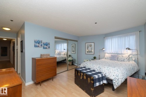 Bedroom featuring a textured ceiling, light wood finished floors, a closet, and baseboard heating - 203 10171 119 Street Nw, Edmonton, AB - Indoor Photo Showing Bedroom