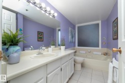 Bathroom with a garden tub, vanity, and light tile patterned floors - 