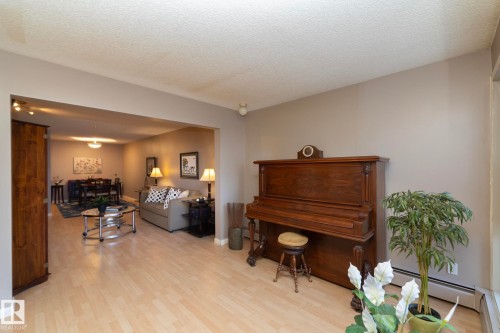 Living room with light wood-style floors and a textured ceiling - 203 10171 119 Street Nw, Edmonton, AB - Indoor