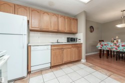 Kitchen with light countertops, white appliances, tasteful backsplash, a textured ceiling, and hanging light fixtures - 