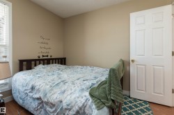 Bedroom featuring wood finished floors, a textured ceiling, and multiple windows - 