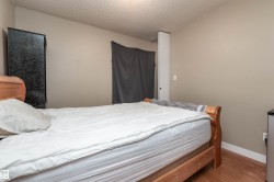 Bedroom with a textured ceiling and wood finished floors - 