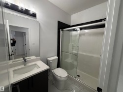 Full bath featuring a shower stall, light marble finish flooring, and vanity - 
