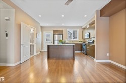 Kitchen with a kitchen island, stainless steel appliances, light wood-style floors, modern cabinets, and recessed lighting - 