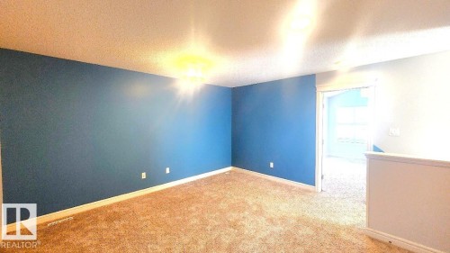 Unfurnished room featuring a textured ceiling and carpet flooring - 4610 Kinsella Landing Sw, Edmonton, AB - Indoor Photo Showing Other Room