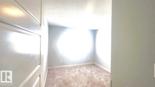 Empty room with carpet flooring and a textured ceiling - 4610 Kinsella Landing Sw, Edmonton, AB - Indoor Photo Showing Other Room