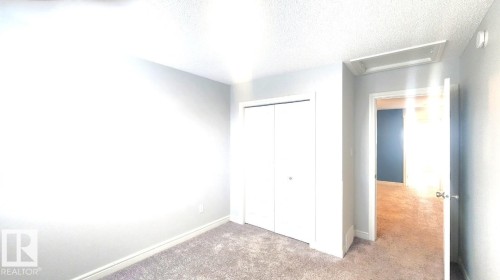Unfurnished bedroom with attic access, carpet floors, a closet, and a textured ceiling - 4610 Kinsella Landing Sw, Edmonton, AB - Indoor Photo Showing Other Room