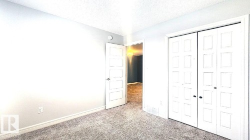 Unfurnished bedroom with carpet flooring, a textured ceiling, and a closet - 4610 Kinsella Landing Sw, Edmonton, AB - Indoor