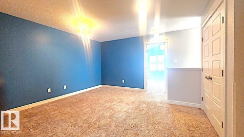 Unfurnished room featuring light carpet and a textured ceiling - 4610 Kinsella Landing Sw, Edmonton, AB - Indoor Photo Showing Other Room