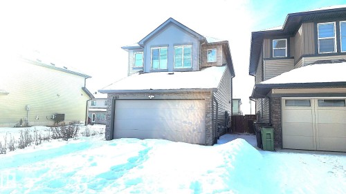 View of front facade with stone siding and a garage - 4610 Kinsella Landing Sw, Edmonton, AB - Outdoor