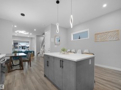 Kitchen with recessed lighting, hanging light fixtures, light wood-style flooring, a center island, and gray cabinetry - 