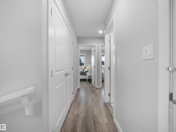 Corridor with light wood-type flooring and recessed lighting - 