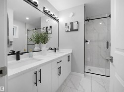 Full bathroom featuring double vanity, a marble finish shower, and light marble finish floors - 
