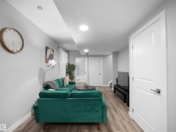 Living room with light wood finished floors, stairway, and recessed lighting - 