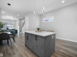 Kitchen featuring hanging light fixtures, a center island, recessed lighting, light wood-style floors, and modern cabinets - 