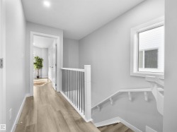 Corridor featuring light wood-style floors and an upstairs landing - 