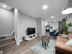 Legal basement suite Living room featuring recessed lighting, light wood-type flooring, and stairway - 