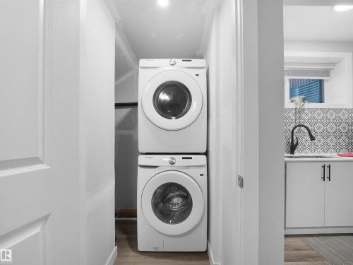 Legal basement suite laundry featuring estacked washer and dryer, light wood-type flooring, and recessed lighting - 10913 159 Street, Edmonton, AB - Indoor Photo Showing Laundry Room