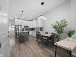 Kitchen featuring white cabinets, appliances with stainless steel finishes, light wood-style floors, pendant lighting, and recessed lighting - 