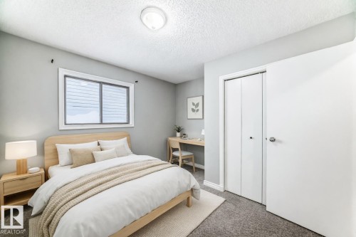 Bedroom featuring carpet flooring, a closet, a desk, and a textured ceiling - 2928 49A Street, Edmonton, AB - Indoor Photo Showing Bedroom