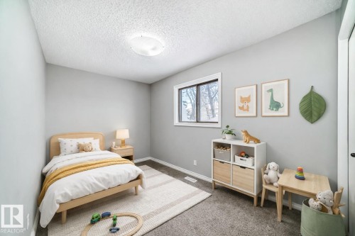 Carpeted bedroom featuring a textured ceiling and baseboards - 2928 49A Street, Edmonton, AB - Indoor Photo Showing Bedroom