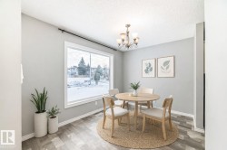 Dining space featuring a textured ceiling, light wood finished floors, and a chandelier - 
