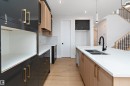 Kitchen featuring light wood-style floors, light stone counters, modern cabinets, recessed lighting, and a center island with sink - 38 Astoria Place, Devon, AB  - Indoor Photo Showing Kitchen With Double Sink With Upgraded Kitchen 