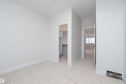 Unfurnished bedroom with a walk in closet and light carpet - 38 Astoria Place, Devon, AB - Indoor Photo Showing Other Room