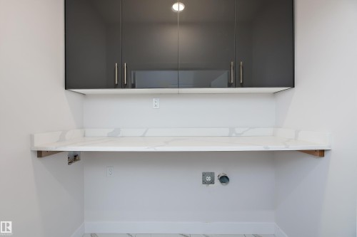Washroom with cabinet space and hookup for a washing machine - 38 Astoria Place, Devon, AB - Indoor