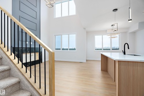 Stairs featuring wood finished floors and a high ceiling - 38 Astoria Place, Devon, AB - Indoor