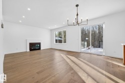 Unfurnished living room with a glass covered fireplace, recessed lighting, light wood-type flooring, and a chandelier - 