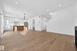 Unfurnished living room featuring light wood finished floors, a chandelier, a fireplace, recessed lighting, and stairs - 