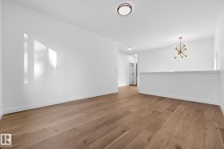 Unfurnished room featuring a chandelier and light wood-style floors - 