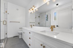 Bathroom featuring double vanity, concrete flooring, and a stall shower - 