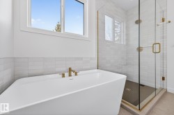 Bathroom featuring tile walls, a freestanding bath, and a shower stall - 